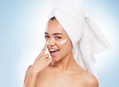 Buy stock photo Towel, skincare and portrait of woman in studio for morning routine, collagen and cosmetic benefits. Female person, smile and cream with point for dermatology, shine and happiness on blue background