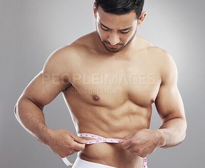 Buy stock photo Man, tape measure and lose weight results in studio or waist size for progress, grey background or athlete. Male person, shirtless and workout training or diet for bodybuilder abs, growth or muscle