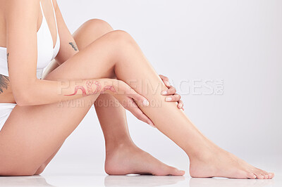 Buy stock photo Cropped shot of an unrecognisable woman sitting and posing in her underwear in the studio