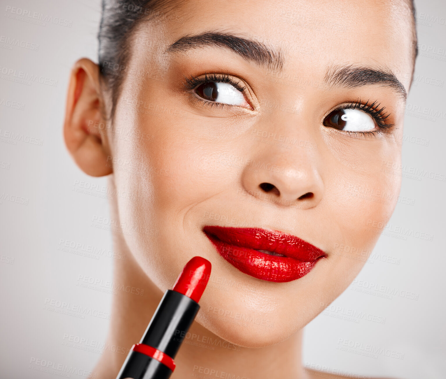 Buy stock photo Studio shot of an attractive young woman applying red lipstick against a grey background