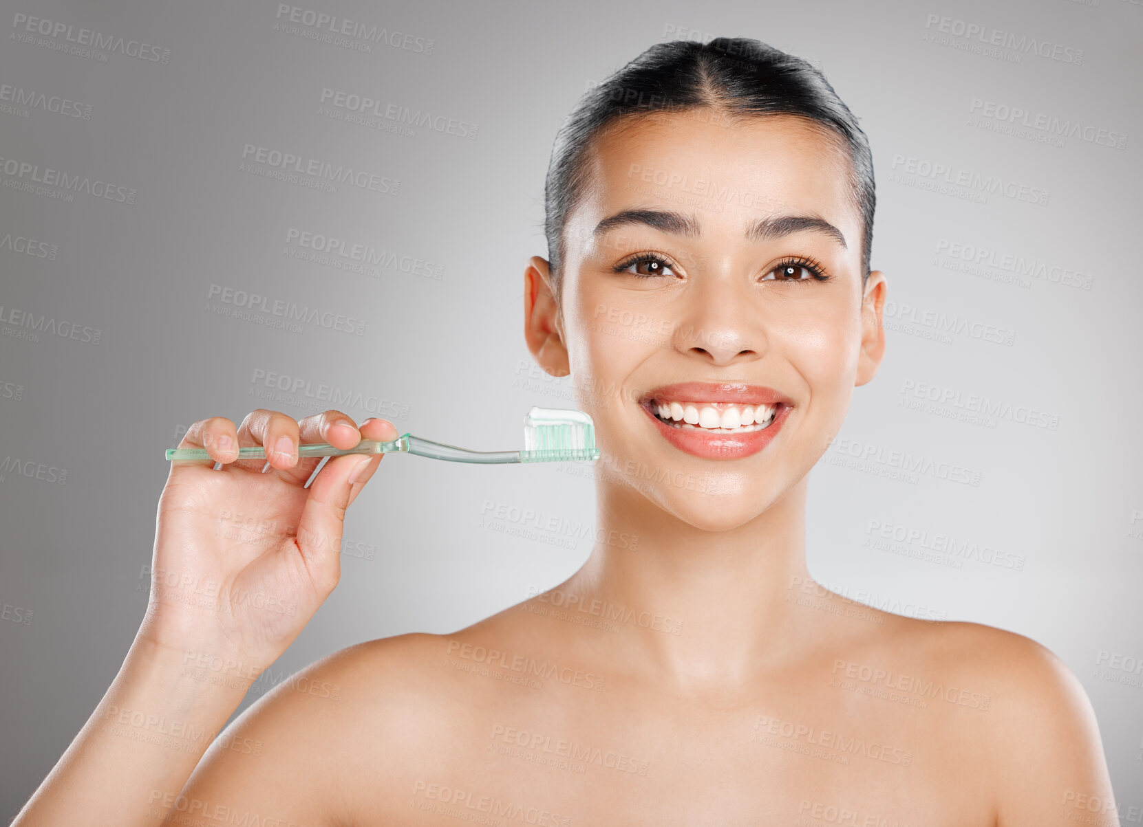 Buy stock photo Studio shot of an attractive young woman brushing her teeth against a grey background