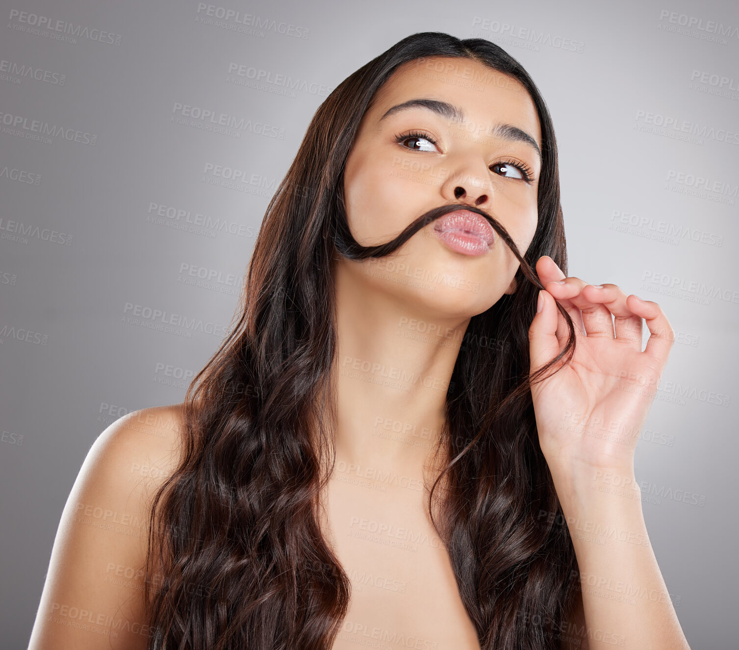 Buy stock photo Studio shot of an attractive young woman making a moustache with her hair against a grey background