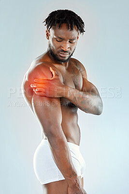Buy stock photo Studio shot of a muscular young man experiencing shoulder pain