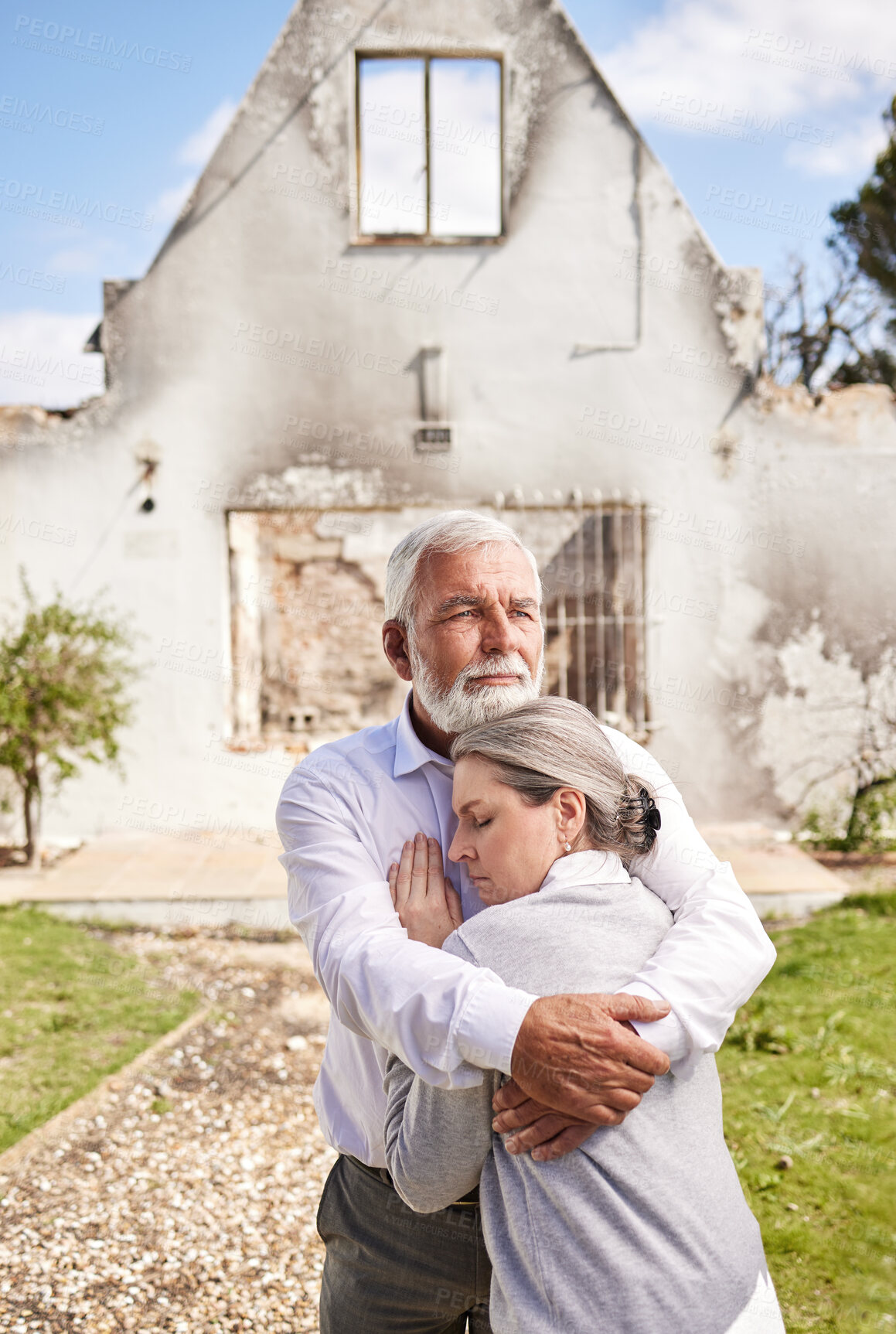 Buy stock photo Couple, home in ruins after fire and hug at accident, disaster or crisis with hope and support with insurance. Property, senior man and woman hugging outside burned house,  grief and real estate loss