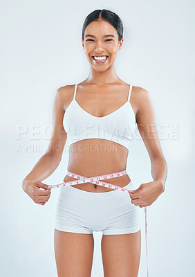 Buy stock photo Happy woman, portrait and weight loss with tape measure for diet or nutrition on a gray studio background. Excited female person or model with smile for slim body size, fitness or health and wellness