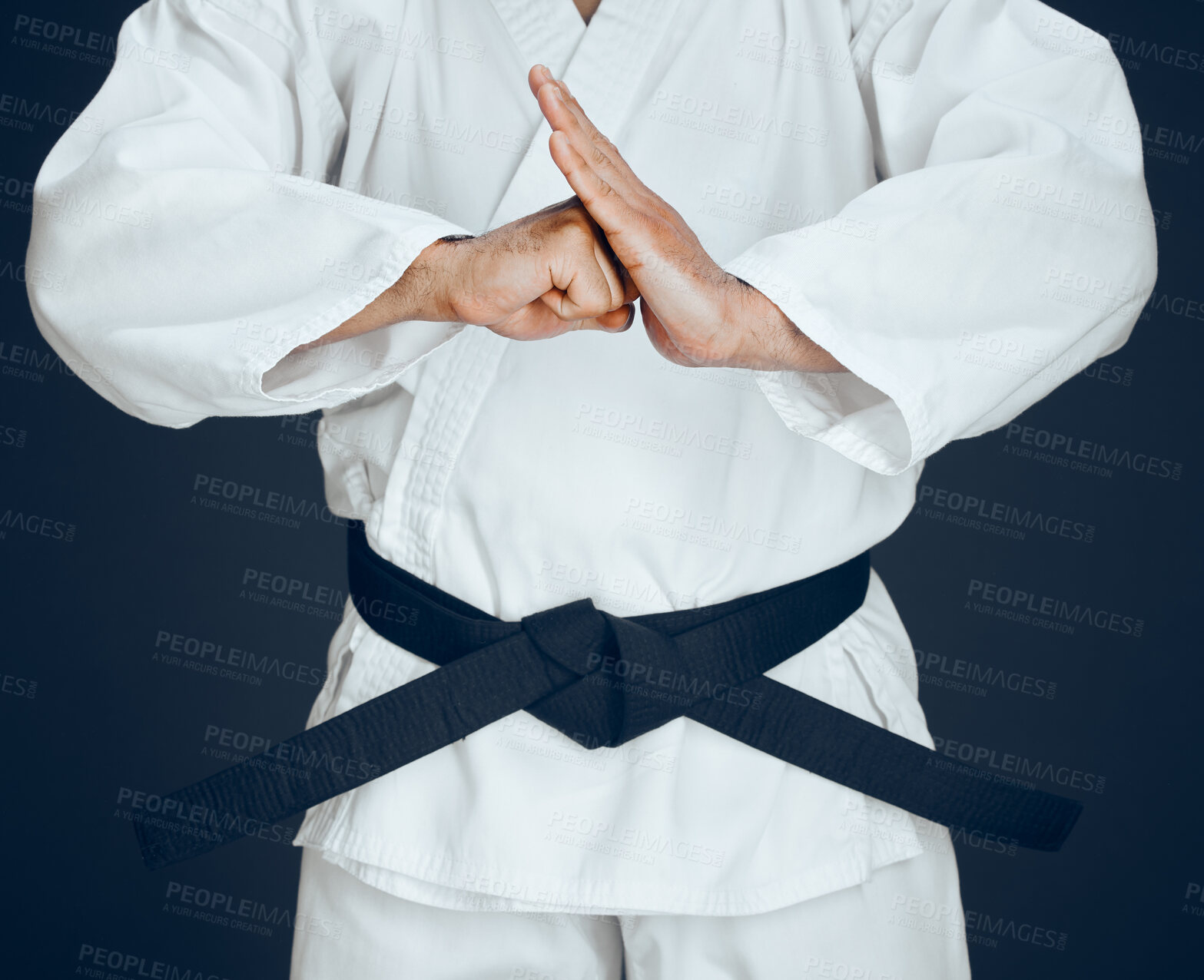 Buy stock photo Cropped shot of an unrecognizable male martial artist practicing karate in studio against a dark background