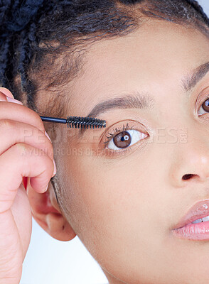Buy stock photo Studio portrait of an attractive young woman using using mascara against a grey background