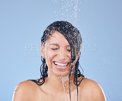 Buy stock photo Shot of a beautiful young woman taking a shower against a blue background