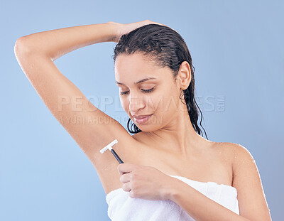 Buy stock photo Happy, woman and razor for shaving armpit, grooming and cleaning with towel for skincare routine in studio. Smile, female person or model for hair removal, hygiene and dermatology on blue background