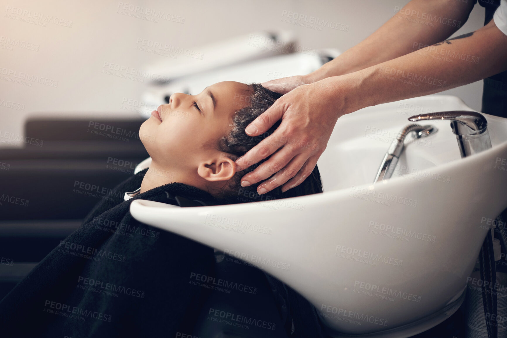 Buy stock photo Washing, kid or hands of hairdresser with girl in salon basin for natural scalp care or cleaning treatment. Rinse, spa or beauty service for client, child or shampoo cosmetics for health or wellness