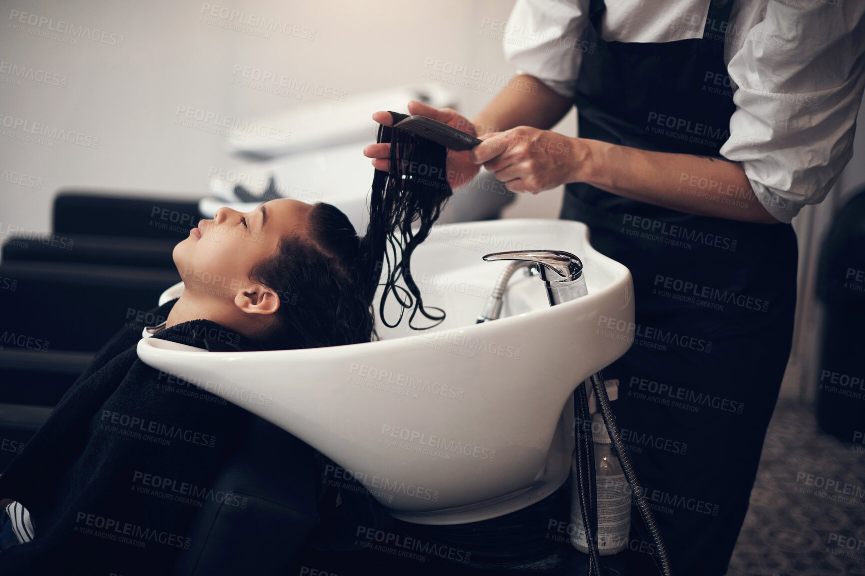 Buy stock photo Washing hair, comb or hands of stylist with child in salon basin for scalp or natural cleaning treatment. Rinse, spa or beauty service for kid, girl client or shampoo cosmetics for health or care