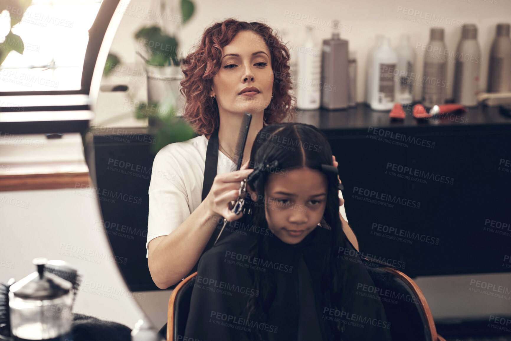 Buy stock photo Shot of a little girl getting her hair done at the salon