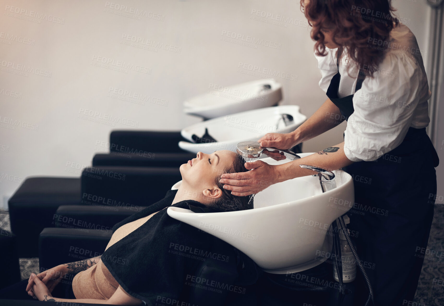 Buy stock photo Washing, woman or hairdresser with customer in salon or basin for scalp or cleaning treatment. Rinse, care and grooming service for client, person or shampoo cosmetics for beauty, wellness or spa