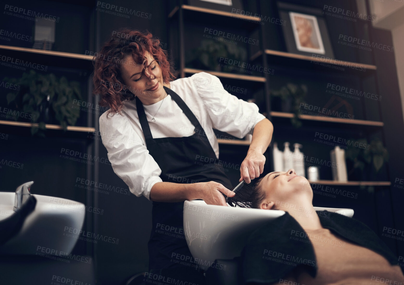 Buy stock photo Washing, woman or hairdresser with client in salon or basin for scalp, care and cleaning treatment. Rinse, relax or grooming service for customer or shampoo cosmetics for beauty, wellness and spa