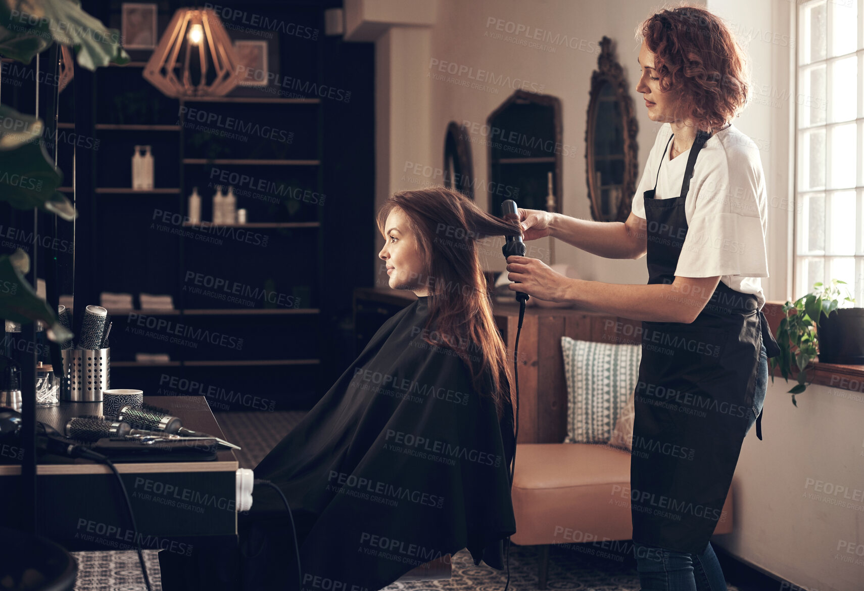 Buy stock photo Hairdresser, woman and client with curling tools for heat treatment, maintenance and haircare of volume style. People, designer and product for blowout, change and healthy shine of salon service