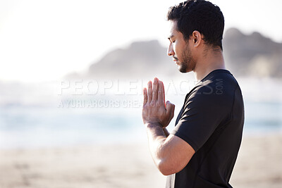 Buy stock photo Cropped shot of a handsome young male athlete meditating on the beach
