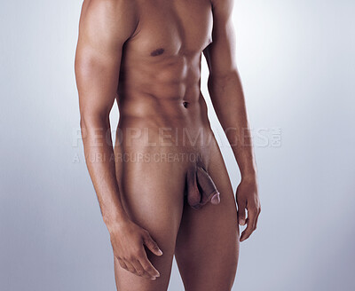 Buy stock photo Studio shot of a hunky young man posing nude against a grey background