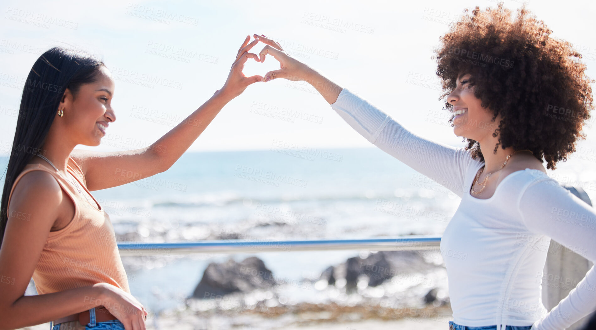 Buy stock photo Friends, heart and hands with women at beach for summer, happy and teamwork. Support, freedom and love with people and holding shape in outdoors for collaboration, faith and community gesture