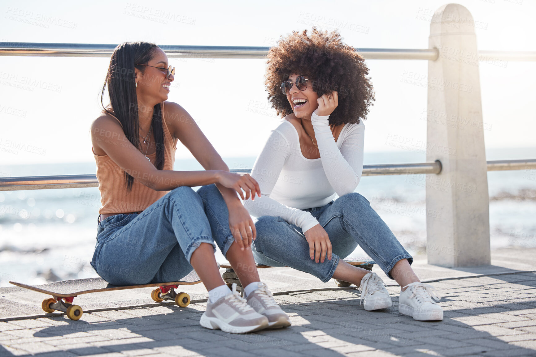 Buy stock photo Happy, friends and women in city with skateboard for weekend, holiday and vacation. Excited, promenade and people laughing for joke outdoors for activity, bonding and adventure by ocean or seaside