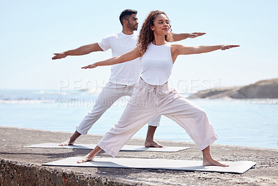 Buy stock photo Couple yoga, beach and exercise outdoor in nature for fitness workout and wellness. African woman and a man at ocean for warrior pose, stretching or pilates training for peace, freedom or mindfulness