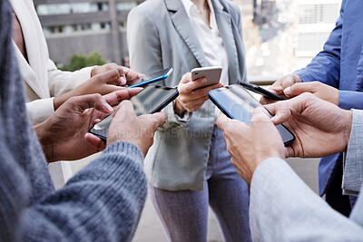 Buy stock photo Shot of a group of unrecognisable businesspeople using their cellphones together at and outside meeting