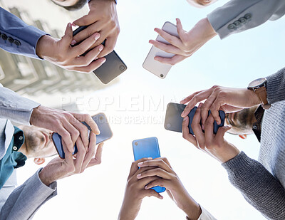 Buy stock photo Shot of a group of unrecognisable businesspeople using their cellphones together at and outside meeting