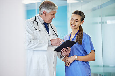 Buy stock photo Shot of two doctors using a digital tablet together at a hospital
