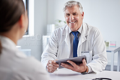 Buy stock photo Shot of a mature male doctor having a consultation with a patient at a clinic
