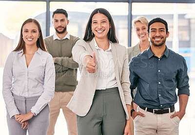Buy stock photo Shot of an attractive young businesswoman standing in the office with her colleagues and showing a thumbs up
