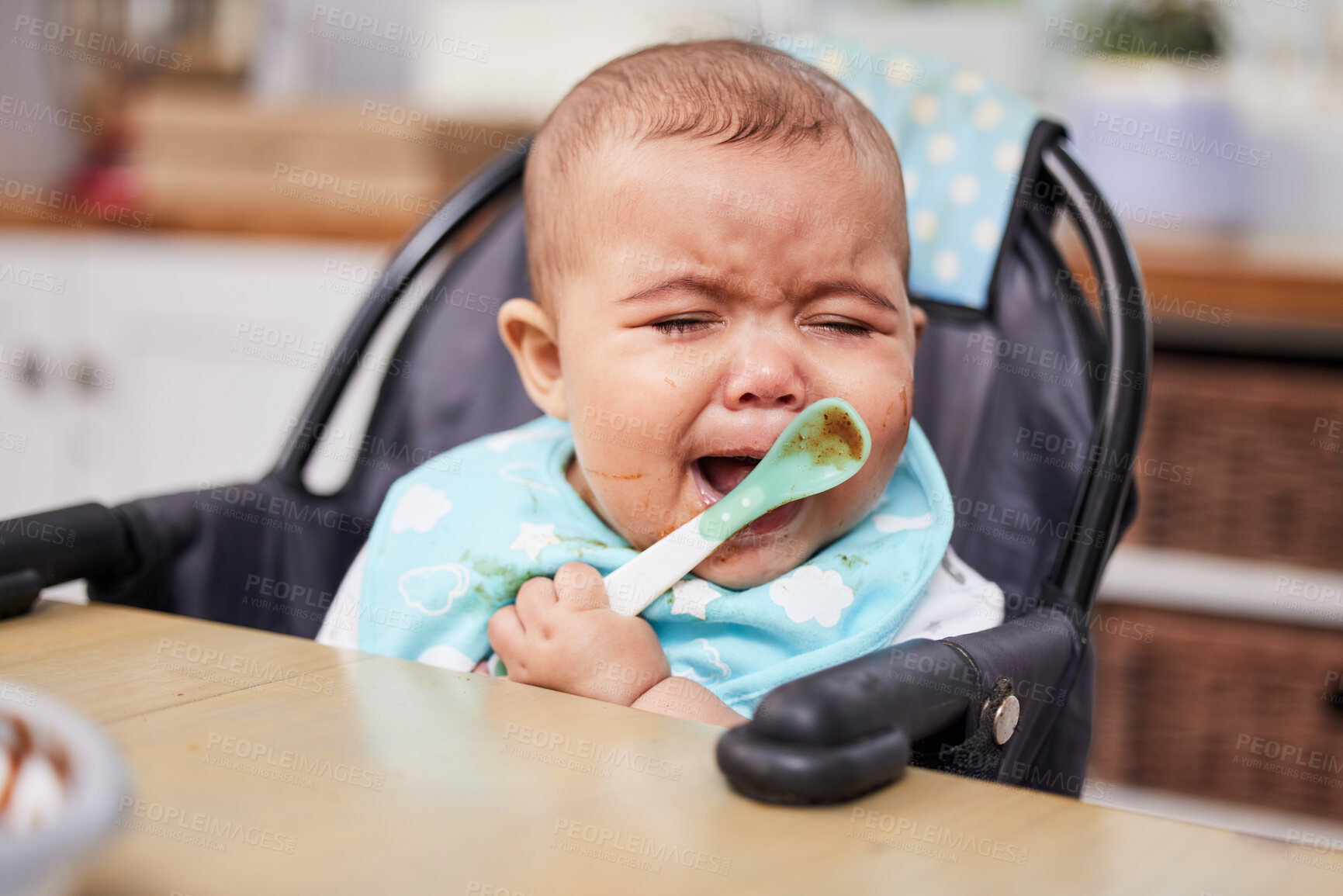 Buy stock photo Baby, sad and crying or eating in home with spoon for nutrition, healthy development or tired in feeding chair. Child, unhappy or frustrated for reflux, problem and hungry in dining room of house