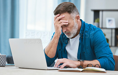 Buy stock photo Shot of a mature businessman experiencing a headache while working on his laptop