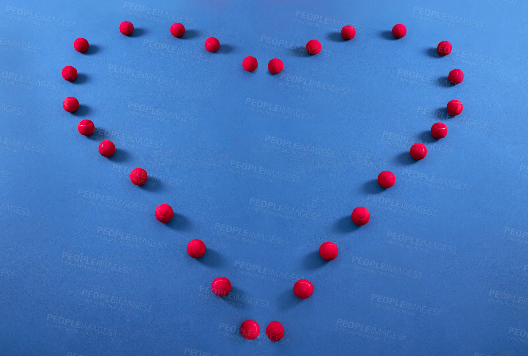 Buy stock photo Heart, pattern and tennis ball on a floor for fitness, health lifestyle and cardiovascular exercise in empty studio. Red, balls and sports equipment in frame for cardio wellness, message and workout