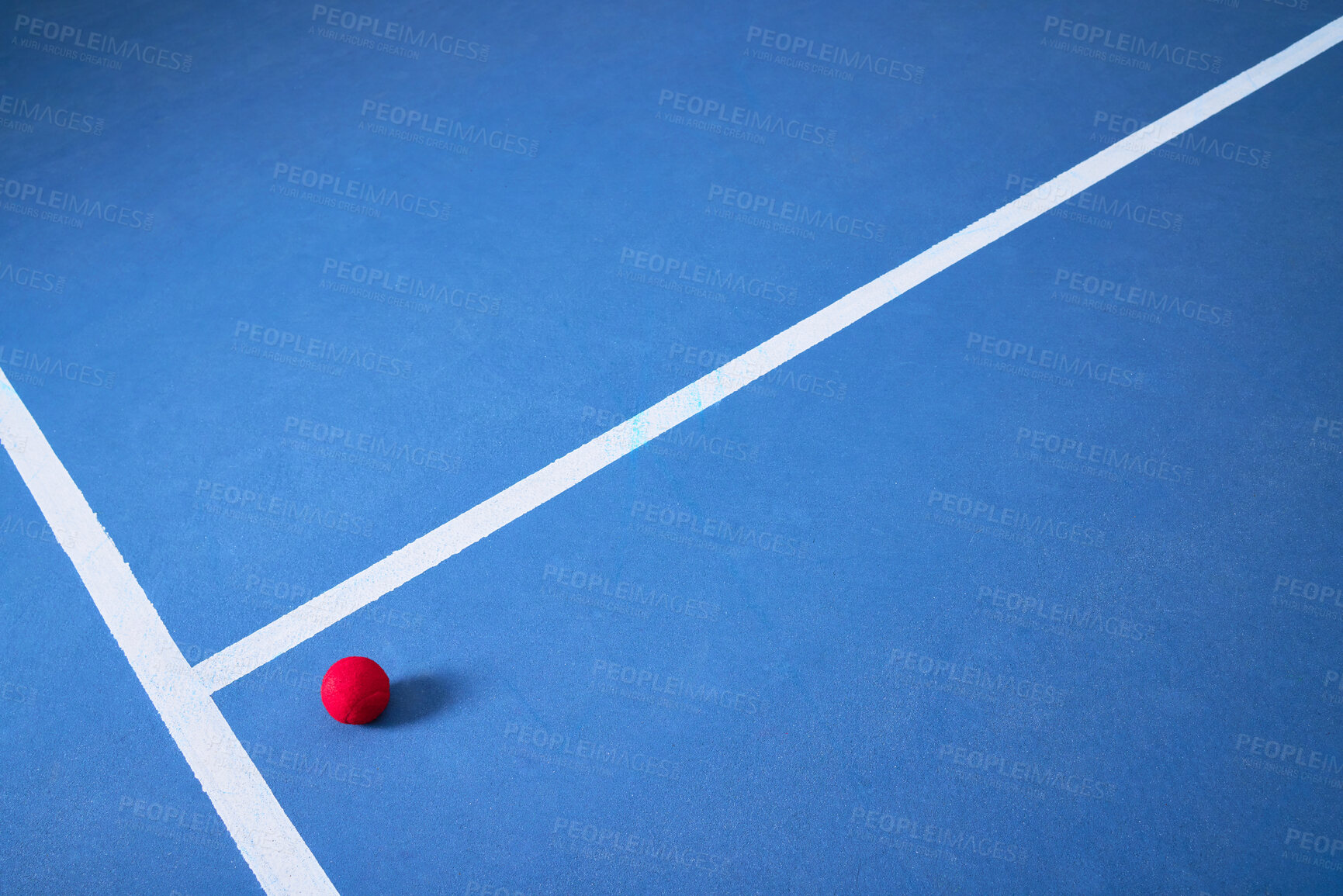 Buy stock photo Single, ground and tennis ball for game or sport, practice and training for skill development for tournament or match. Blue court or pitch, red equipment and floor for athletic activity and fitness.