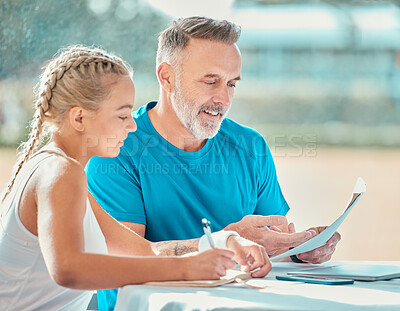 Buy stock photo Shot of a handsome mature coach sitting with a tennis player and discussing a game plan