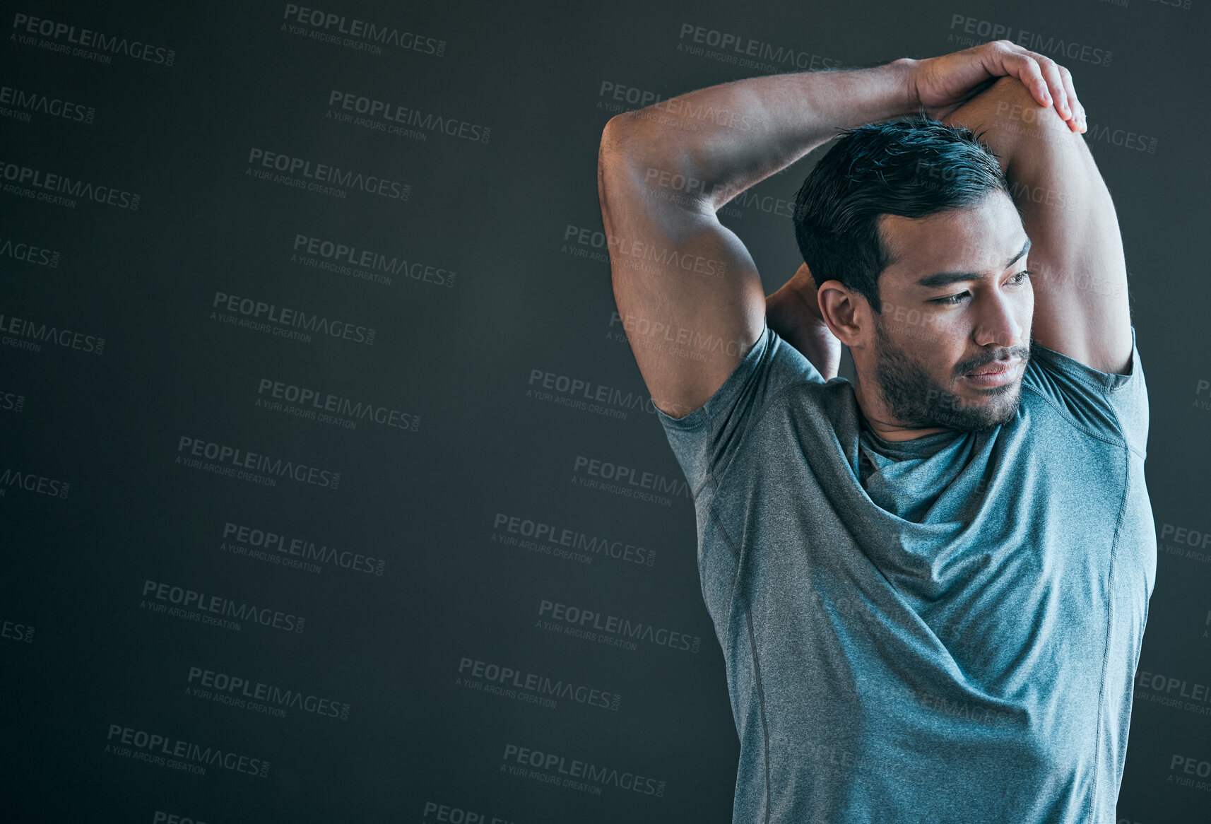 Buy stock photo Cropped shot of a handsome young male athlete warming up against a grey background