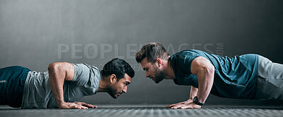Buy stock photo Full length shot of two handsome young male athletes doing pushups face to face against a grey background