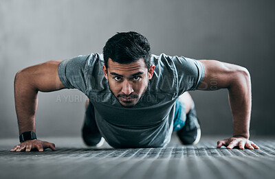 Buy stock photo Full length portrait of a handsome young male athlete doing pushups against a grey background