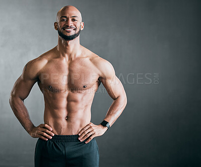 Buy stock photo Cropped portrait of a handsome young male athlete standing shirtless with his hands on his hips against a grey background