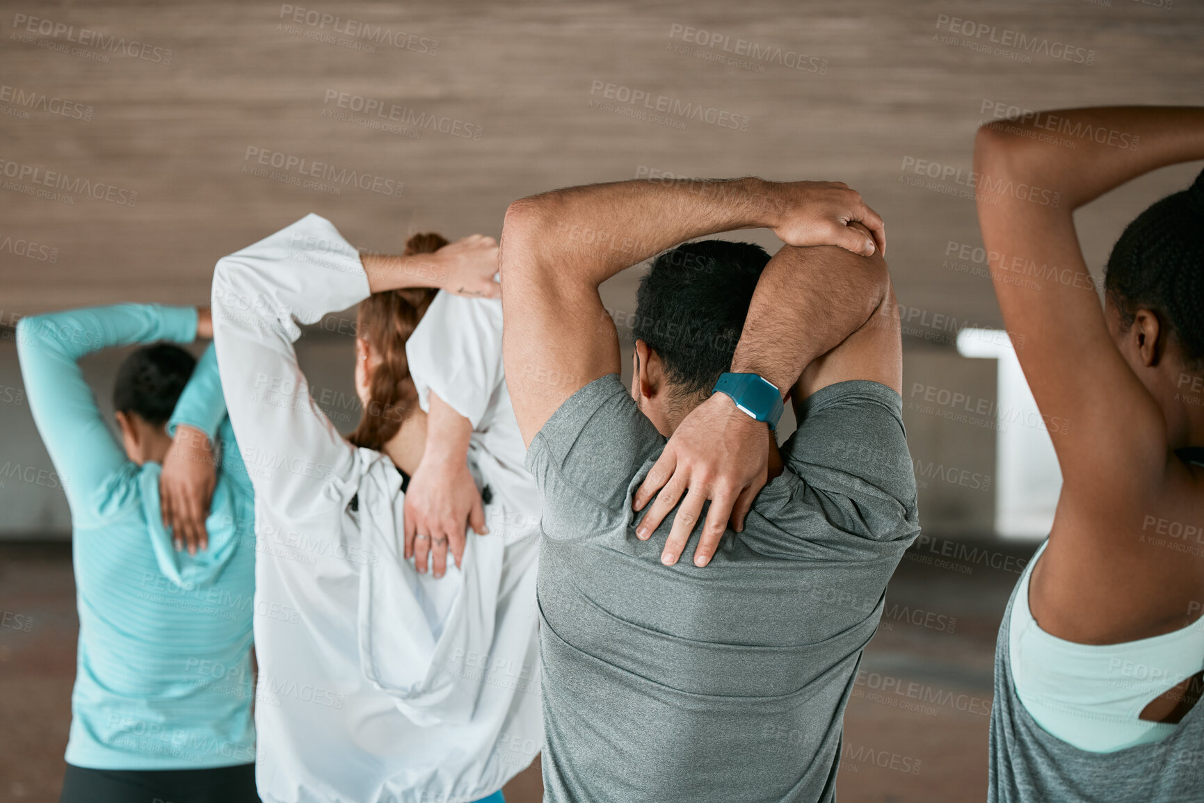 Buy stock photo Shot of a group of friends stretching their arms and shoulders together