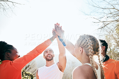 Buy stock photo Shot of a diverse group of friends standing together with their hands in the middle during their outdoor workout