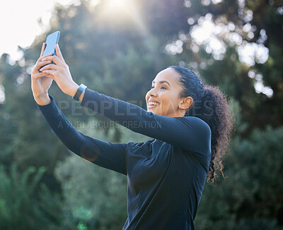 Buy stock photo Shot of a sporty young woman taking selfies while exercising outdoors
