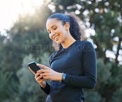 Buy stock photo Shot of a young woman using a cellphone while exercising outdoors