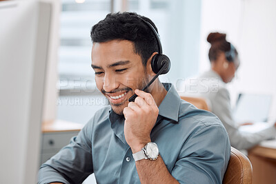 Buy stock photo Shot of a young call centre agent working in an office with his colleague in the background