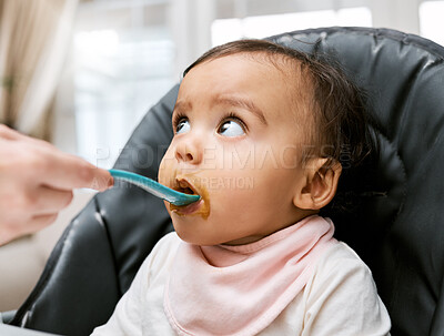 Buy stock photo Shot of a mother feeding her adorable baby girl