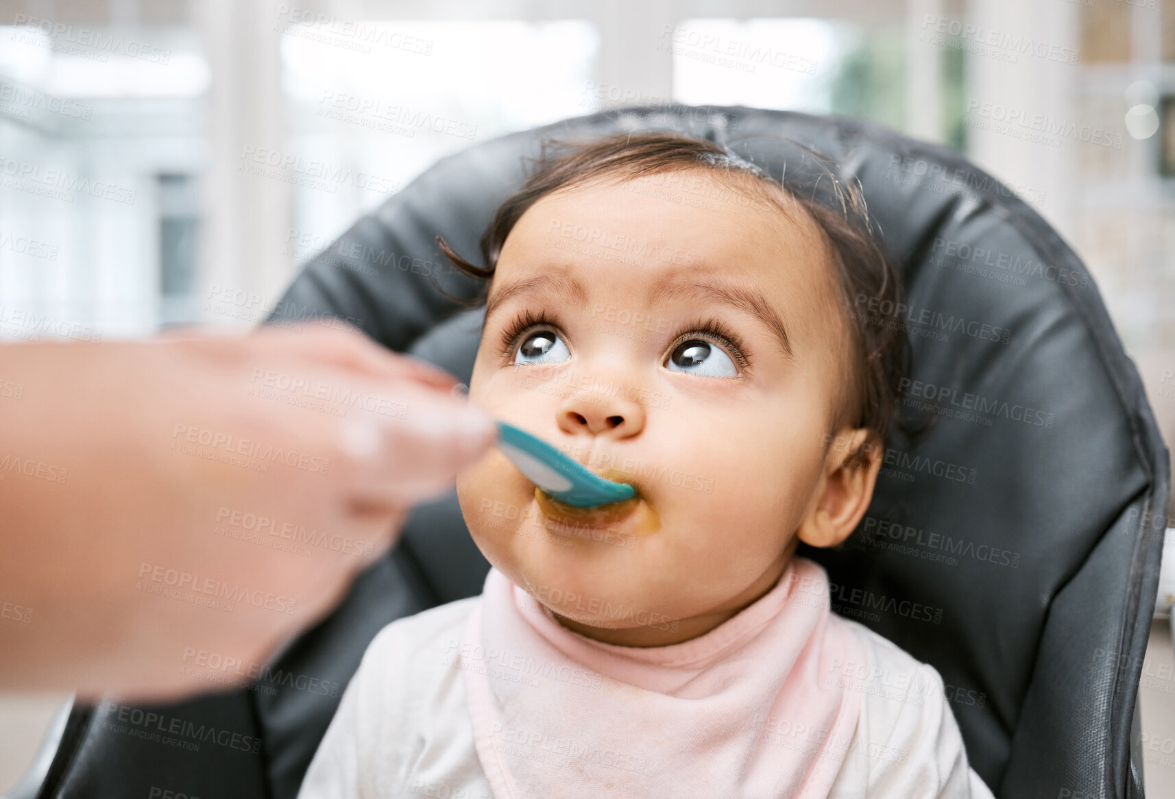 Buy stock photo Adorable, sweet and cute baby eating puree for lunch, dinner or snack in her high chair at home. Child development, food and girl infant kid enjoying meal with spoon for growth and wellness in house.