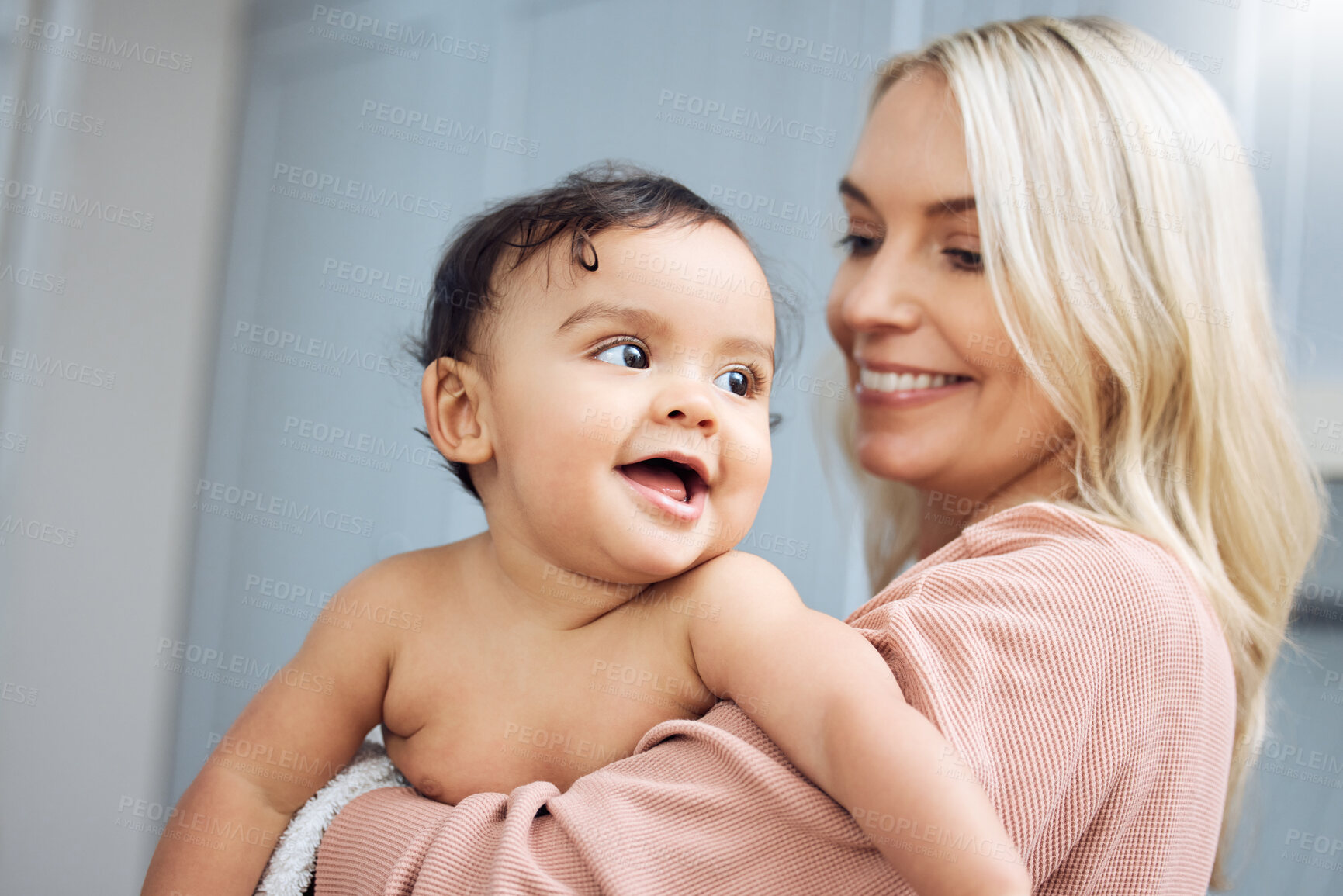 Buy stock photo Love, smile and mother holding with her baby in the nursery room of their modern family home. Happy, bonding and young woman hugging her cute girl infant child with care and affection in their house.