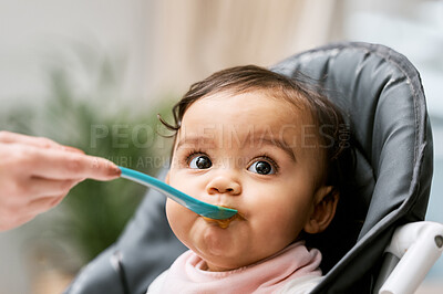 Buy stock photo Cute, sweet and girl baby eating puree for lunch, dinner or snack in her high chair at home. Child development, food and infant kid enjoying a meal with a spoon for growth and wellness in a house.