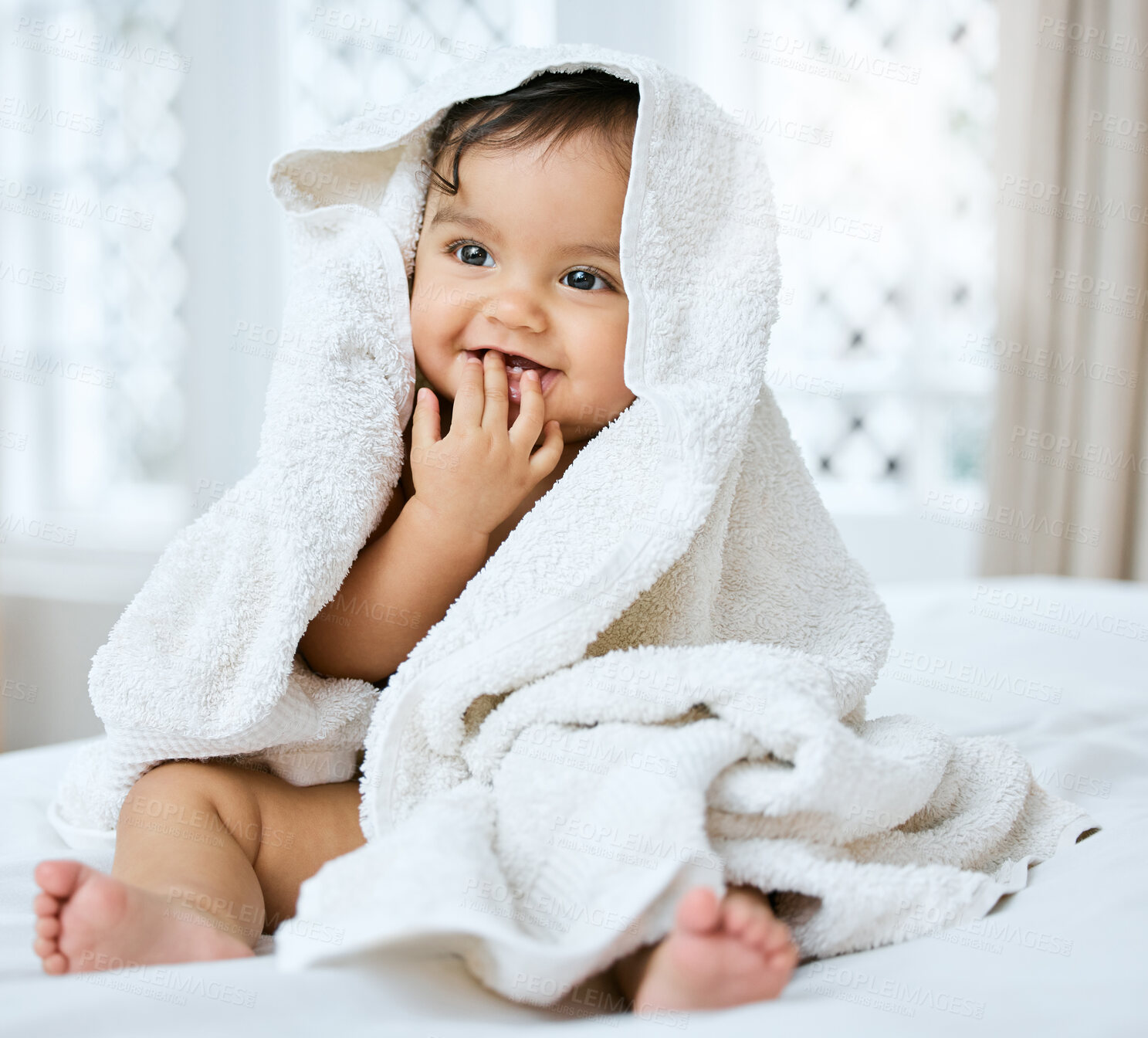 Buy stock photo Shot of an adorable baby covered in a towel after bath time