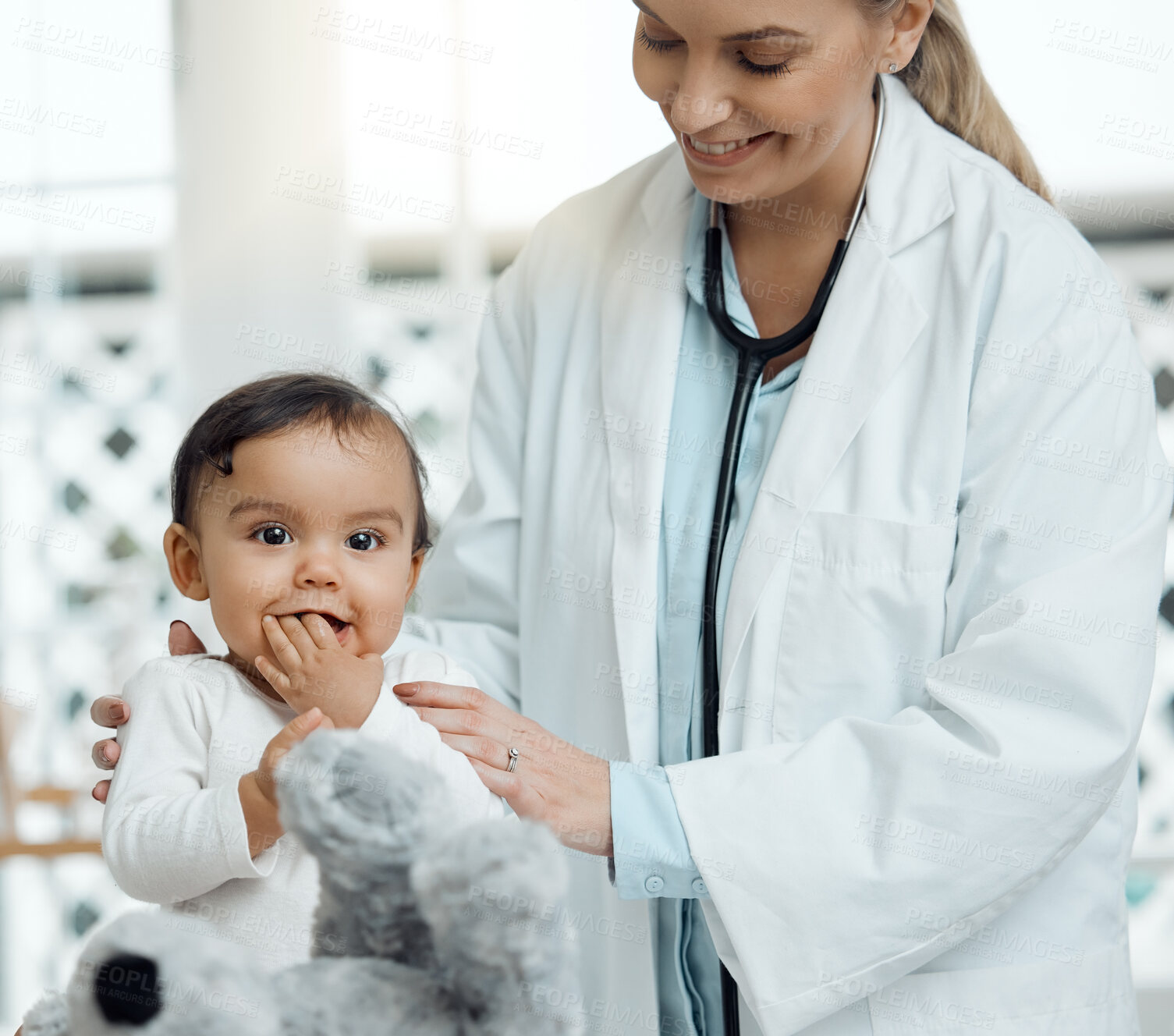 Buy stock photo Shot of a paediatrician examining a baby in a clinic