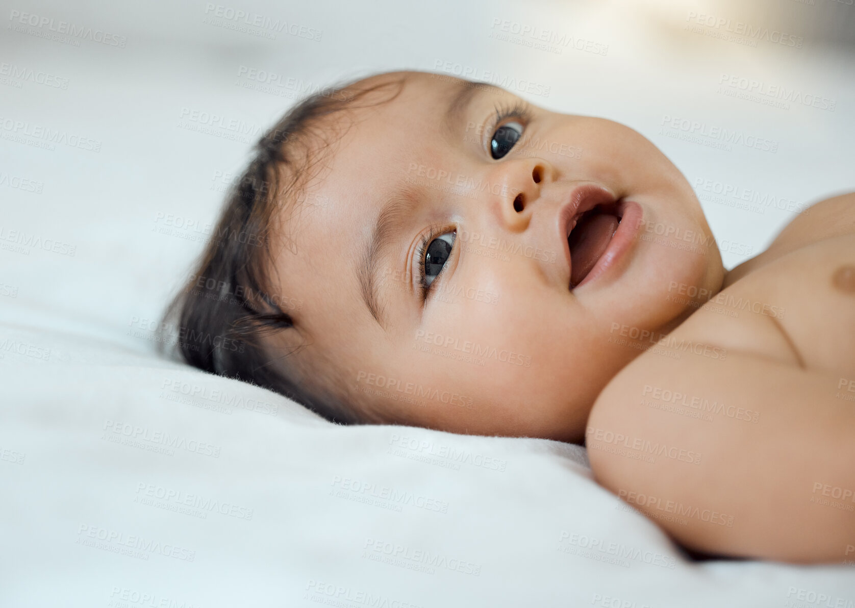 Buy stock photo Shot of an adorable baby girl lying on a bed at home